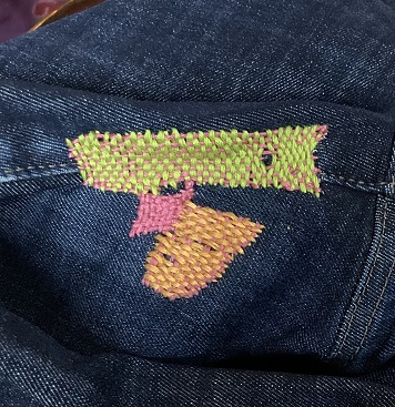 visibly mended jeans in bright colors